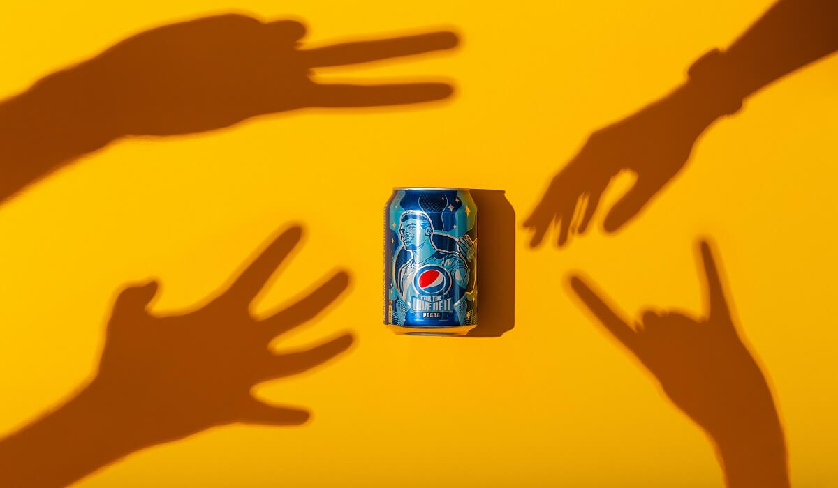 Shadowed hands reaching for a Pepsi.